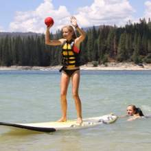 Girl on paddleboard with ball